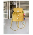 Detail view of yellow lychee leather backpack with bunny logo and colorful letter beads - With Charm / Yellow