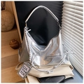 Detailed macro view of metallic silver hobo bag with woven rope and branded square tag - Silver