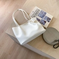 Sac à main blanc texture litchi avec breloque cœur sur un support en bois - Blanc
