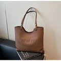 Primer plano detallado del bolso tote de cuero marrón con grabado WWTU y textura litchi - café