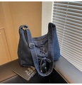 Gros plan du sac seau en jean bleu foncé avec détails de lacets, nœud et boucles métalliques - Bleu foncé