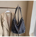 Dettaglio della borsa hobo in denim grigio lavato con bordi a taglio vivo e patch - Nero