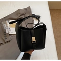 Détail du sac seau noir en cuir grainé avec boucle dorée et large bandoulière - Noir