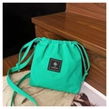 Detail of emerald green drawstring canvas bag with brand label and textured fabric - Turquoise Green