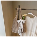 Detail of light brown woven tote bag featuring a decorative white lace bow and embroidery - Khaki