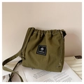 Détail du sac seau vert olive à cordon avec étiquette de marque et surpiqûres blanches - Vert Militaire
