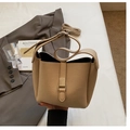 Détail du sac seau beige avec texture cuir galet et boucle en métal sur fond blanc pur - Kaki