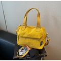 Detalle de un bolso de lona amarillo con asas anchas de tela y un parche de logo - Amarillo