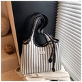 Detail of striped canvas tote bag with black leather trim and COIH'DN2 brand tag on fabric - Black