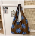 Detailed macro view of the floral print nylon fabric and purple woven tag on hobo bag - Brown