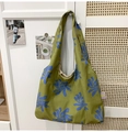Detail of floral printed green nylon crescent bag hanging on a white cabinet handle - Green