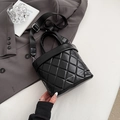 Elegant black quilted bucket bag with wide strap and brand lettering on grey suit - Black