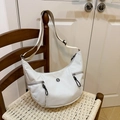 Minimalist beige dumpling shoulder bag with adjustable strap on a woven chair - Gray