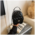 Close-up of black quilted patent leather backpack with metallic turn-lock and chain strap - Black