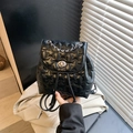 Black star-quilted backpack with silver chain handle and metallic turn-lock closure - Black