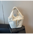 Detail of off-white canvas tote bag featuring dual front pockets with black snap buttons - White