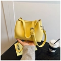 Detail van gele bucket bag van lychee leer met zilveren hardware en modieuze tekst - Geel