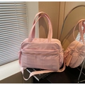 Detail of pink quilted travel tote with front zipper pocket and adjustable shoulder strap - Light Pink