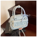 Close-up of light blue mini handbag with pleated PU texture, lace trim and bow handle - Blue