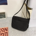 Minimalist matte black nylon crossbody bag with adjustable strap and side brand label - Black