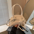 Cremeweiße halbrunde Lederhandtasche mit eleganter Schleife und Perlenanhänger - Cremeweiß