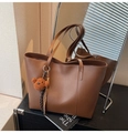 Brown leather tote bag with plush bear charm and woven strap detail in warm lighting - Coffee (With Pendant)