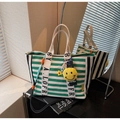 Green and white striped canvas tote bag with yellow smiley face charm and woven strap - Green
