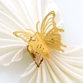 Golden laser-cut butterfly napkin ring with glitter texture on white satin napkin - Sparkling Gold