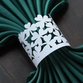 White pearlescent paper napkin ring with clover laser cut design on green napkin - White