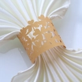 Detailed close-up of golden laser-cut clover napkin rings with pearlescent finish - Gold