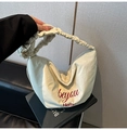 Detail of cream pleated canvas tote with red beyou text and textured nylon material - White