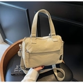 Detail of beige nylon crossbody bag showing the woven handle and brand label - Khaki