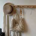 Handcrafted beige straw tote bag with intricate cut-outs and wooden bead straps - Beige and White