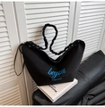 Minimalist black crescent canvas tote bag with ruched shoulder strap and blue text detail - Black