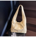 Minimalist beige hobo shoulder bag with drawstring bow detail on a dark background - Off White