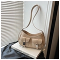 Détail du sac beige avec boucles argentées sur un livre dans un décor de style de vie - Kaki