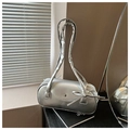 Détail d'un sac oreiller cylindrique argenté avec nœud métallique et rabat aimanté - Argenté