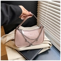 Close-up of pink patent leather handbag with silver metal chains and heart charm - Pink