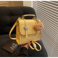 Detail of bright yellow PU leather backpack with silver star buckle and bear charm - Yellow