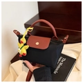Mini black nylon crossbody bag with brown leather handles and a yellow duck pendant - With Charm / Black