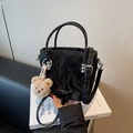 Borsa a secchiello nera increspata con tracolla regolabile e charm a orsetto - Nero