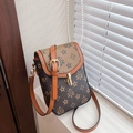 Détail d'un sac bandoulière vintage avec fermoir doré tournant sur un rebord de fenêtre blanc - Marron