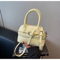 Dettaglio borsa in pelle a grana litchi giallo chiaro con tracolla regolabile e manici - Giallo