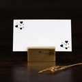 Close-up of golden rectangular metal place card holder with heart motif card on wood - White