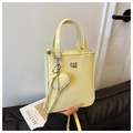 Schicke hellgelbe Mini-Handtasche aus Lackleder mit Herzanhänger und Silber-Logo - Gelb