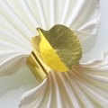 Detailed close-up of a golden leaf-shaped napkin ring on a folded white cloth - 17.8CM / Mirror Gold