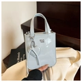 Schicke hellblaue Mini-Handtasche aus Lackleder mit Herzanhänger und Pan Tor Logo - Blau
