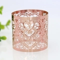 Close-up of rose gold napkin ring with heart laser-cut design for wedding decor - Mirror Rose Gold