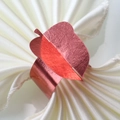 Macro detail of red metallic leaf napkin ring on elegant white silk fabric - Mirror Apple Gold