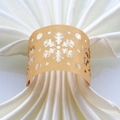 Close-up of golden laser-cut snowflake paper napkin ring with elegant hollow pattern - 50 Pieces / Gold